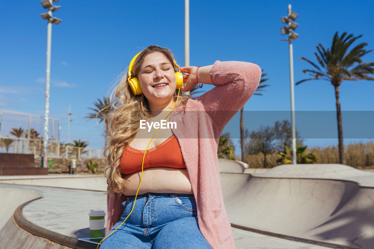 Young woman sitting in skateboard park