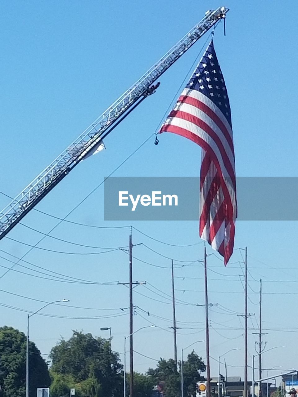 LOW ANGLE VIEW OF FLAG FLAGS AGAINST CLEAR BLUE SKY