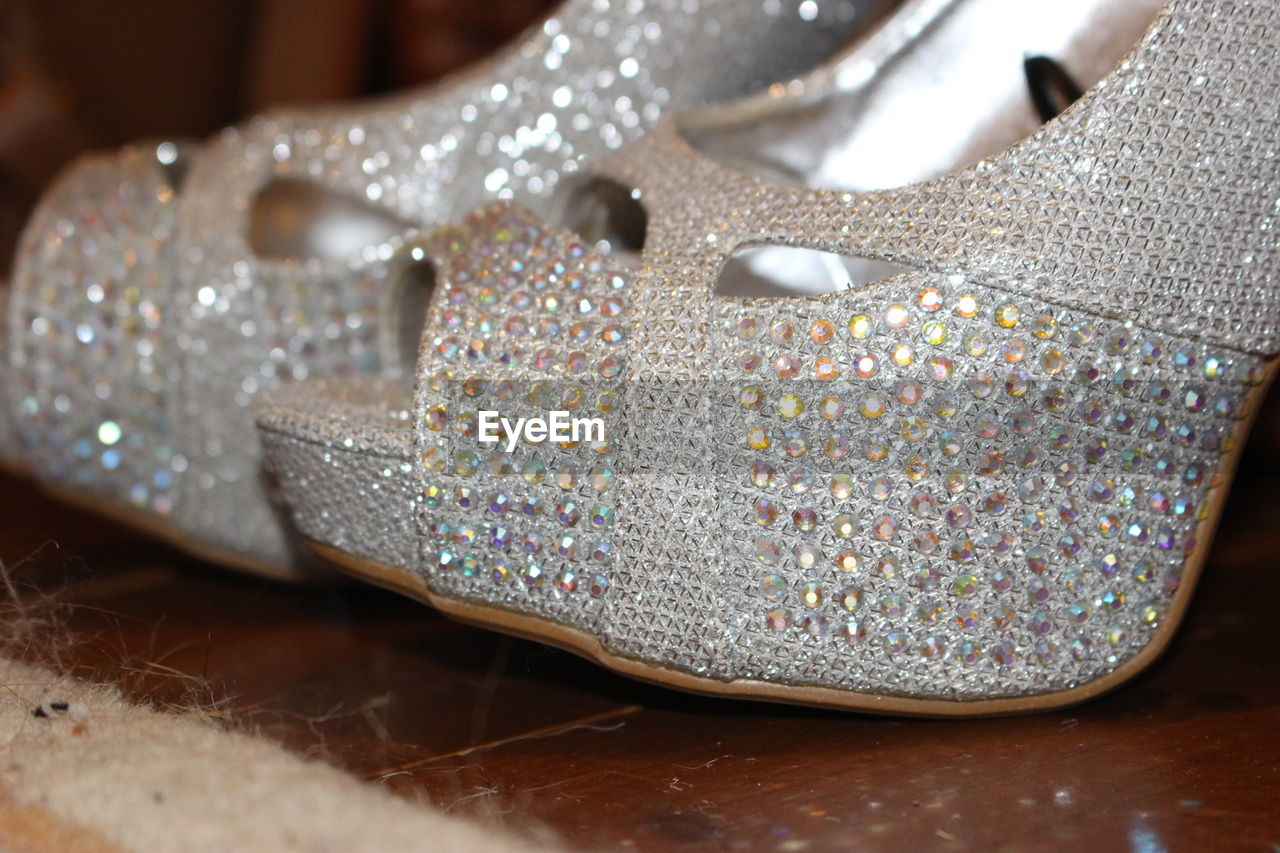 Close-up of silver heel on wooden floor