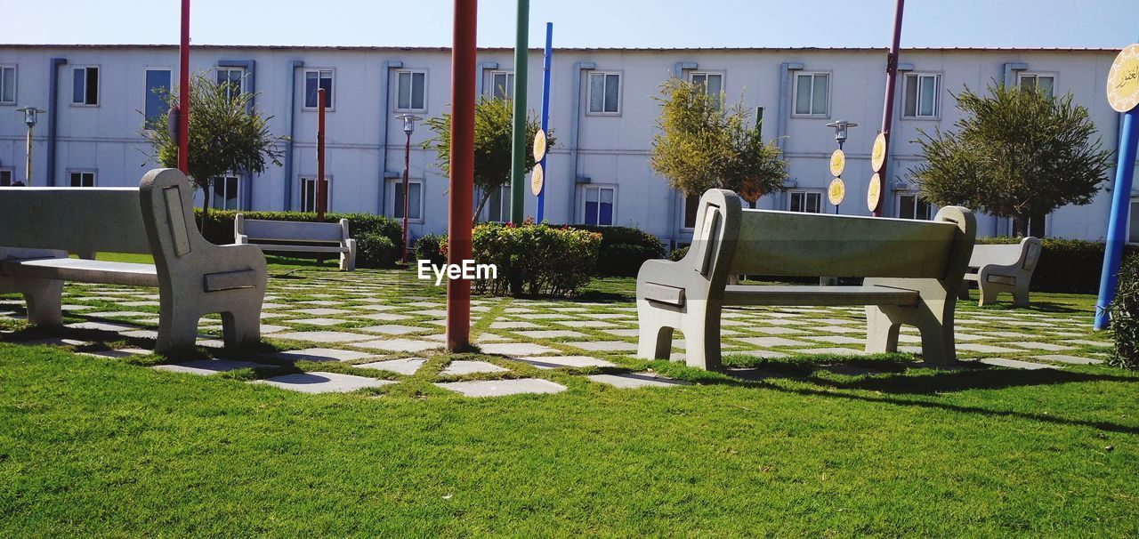 EMPTY CHAIRS AND TABLE IN LAWN ON FIELD