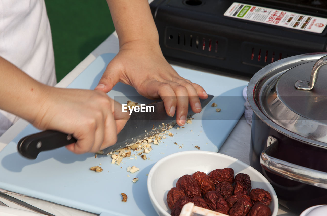 Cropped image of chef chopping nuts at table during cooking competition