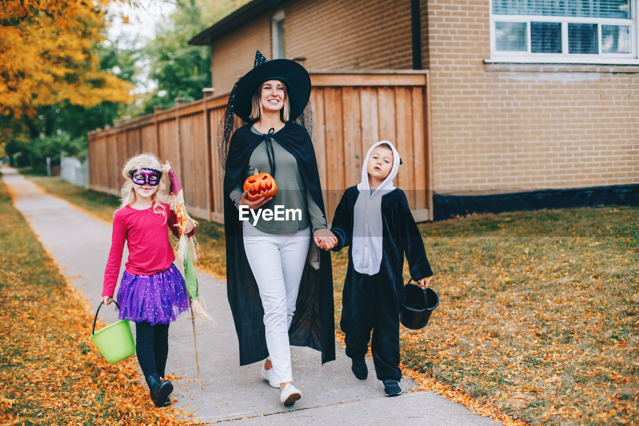 Trick or treat. mother with children going to trick or treat on halloween holiday. mom with kids 