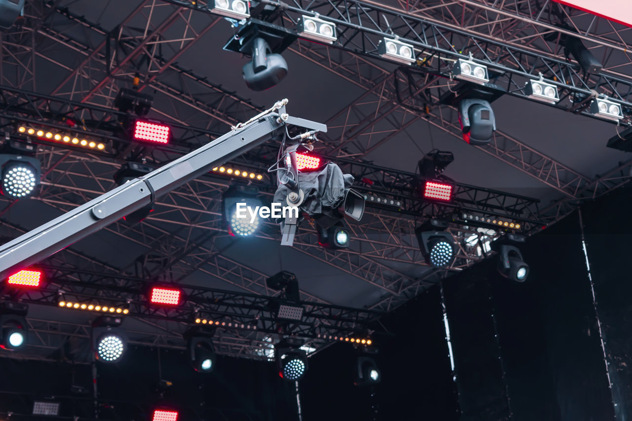 Video camera on the background of the stage spotlights of the music show