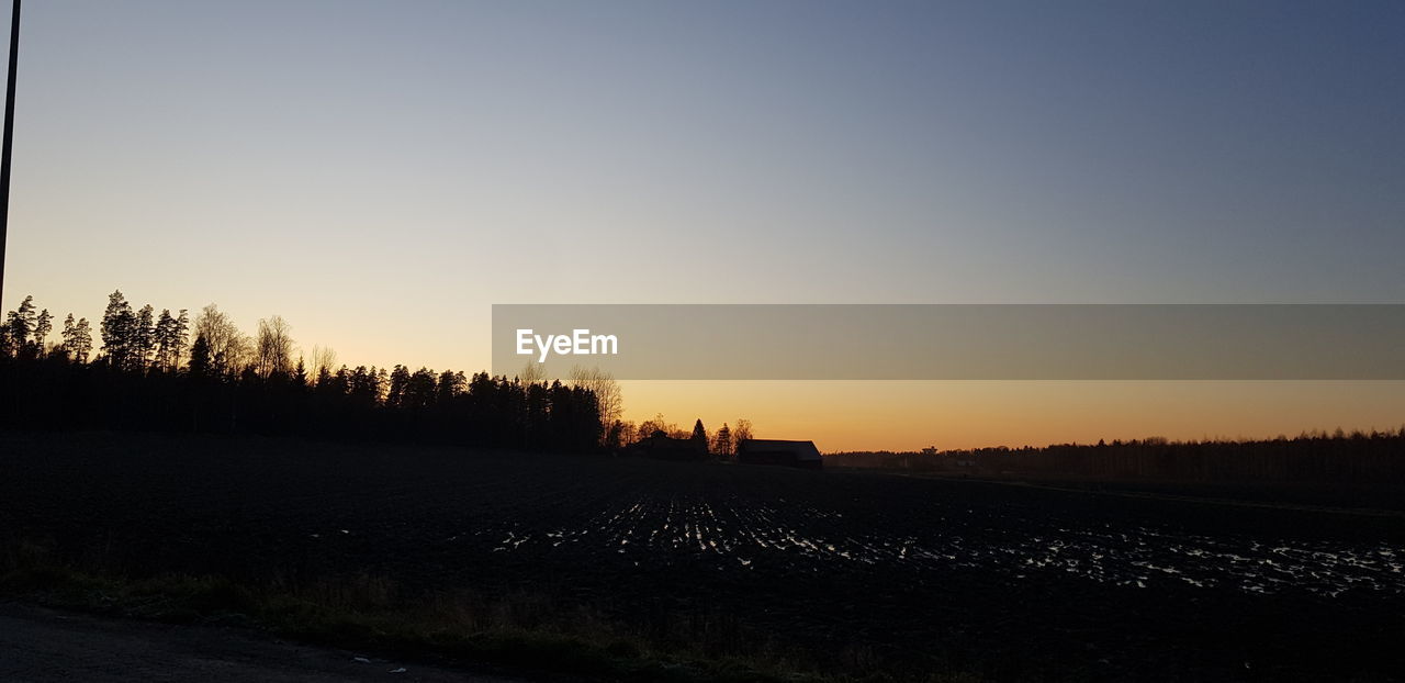 SCENIC VIEW OF SILHOUETTE FIELD AGAINST CLEAR SKY