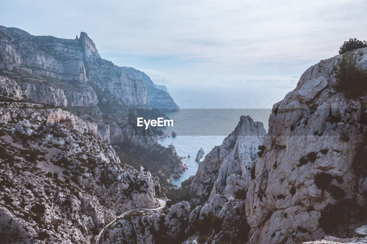 Rock formations by sea against sky