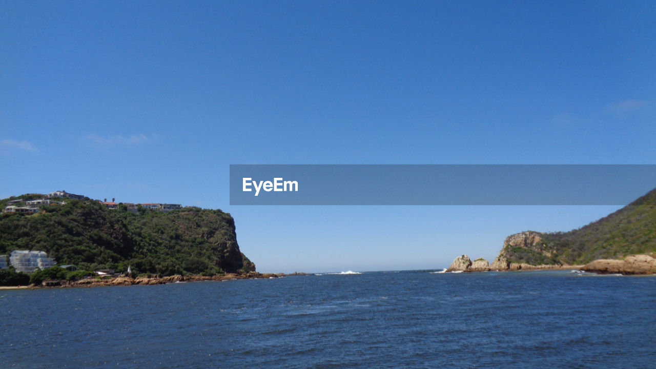 Scenic view of sea against clear blue sky