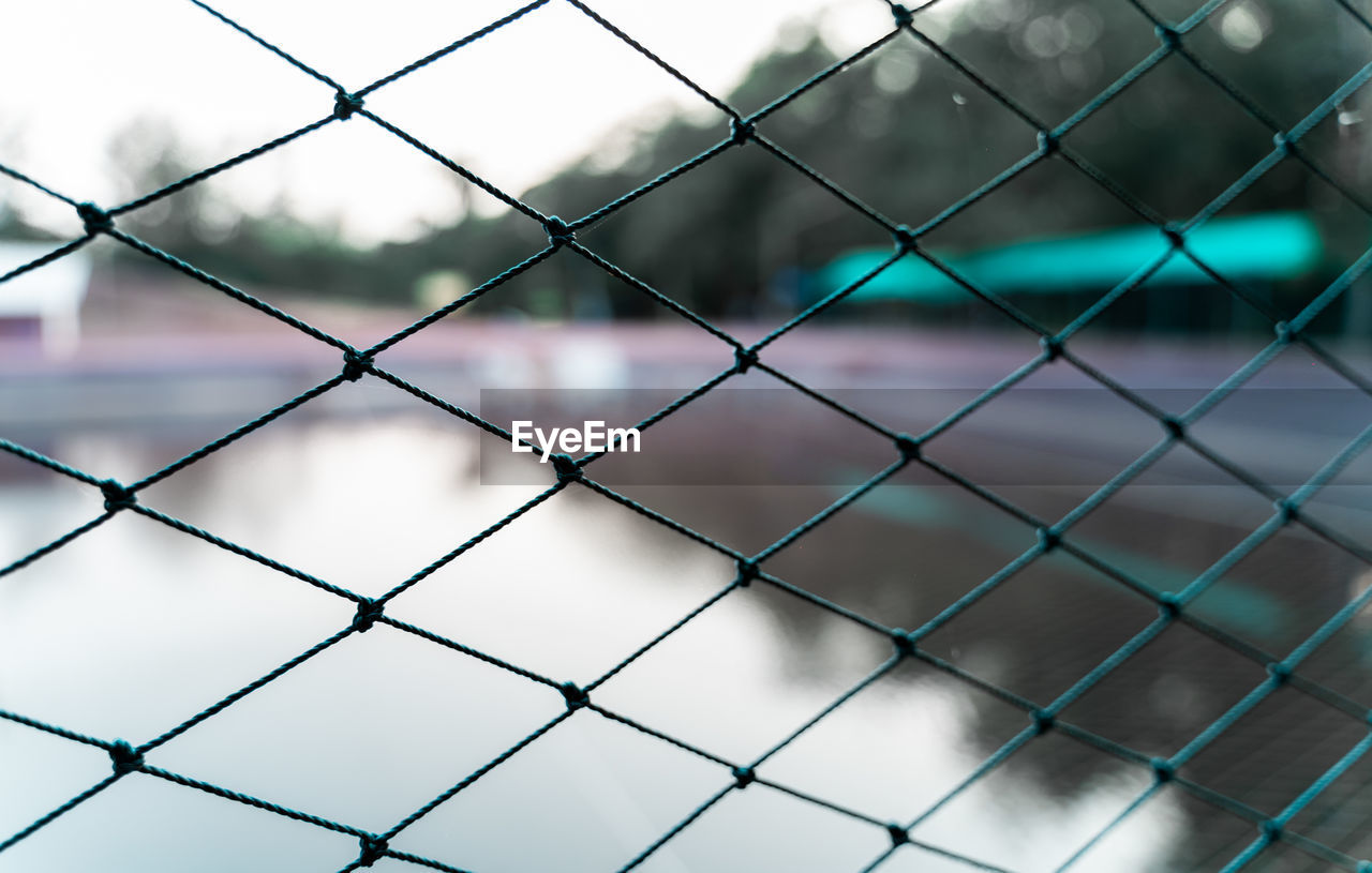 FULL FRAME SHOT OF CHAINLINK FENCE SEEN THROUGH METAL WIRE