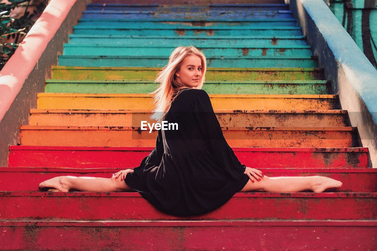 Beautiful female fashion dancer in urban colorful staircase