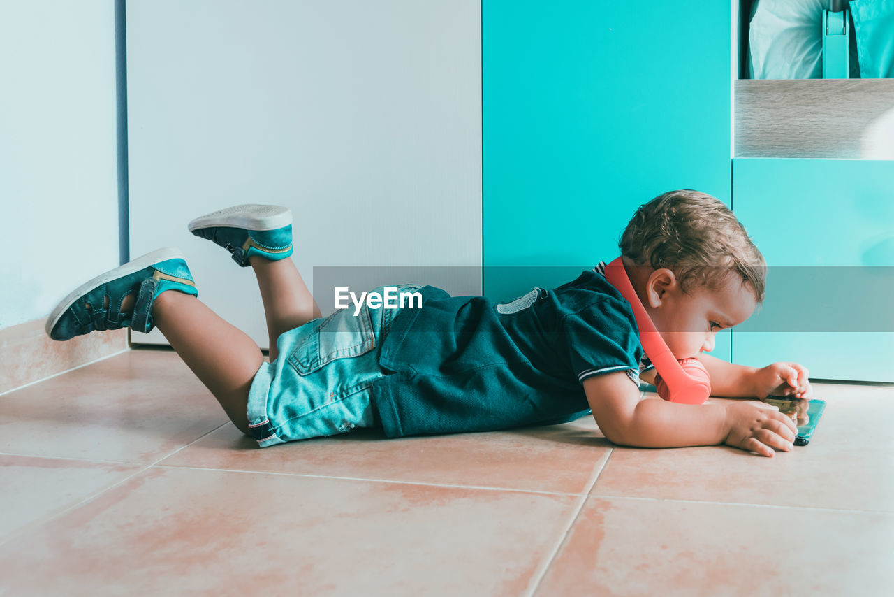 Boy lying on floor at home