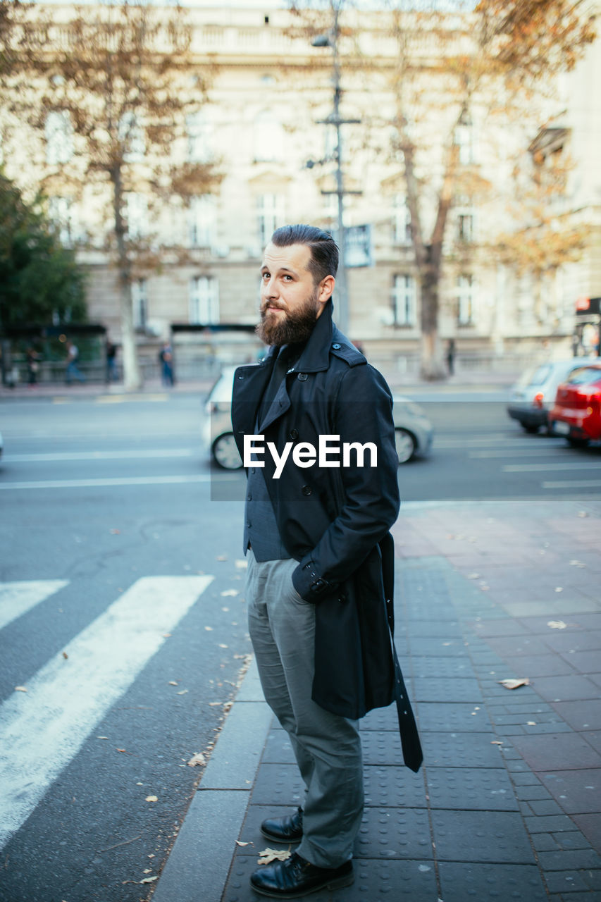 YOUNG MAN LOOKING AT CITY STREET