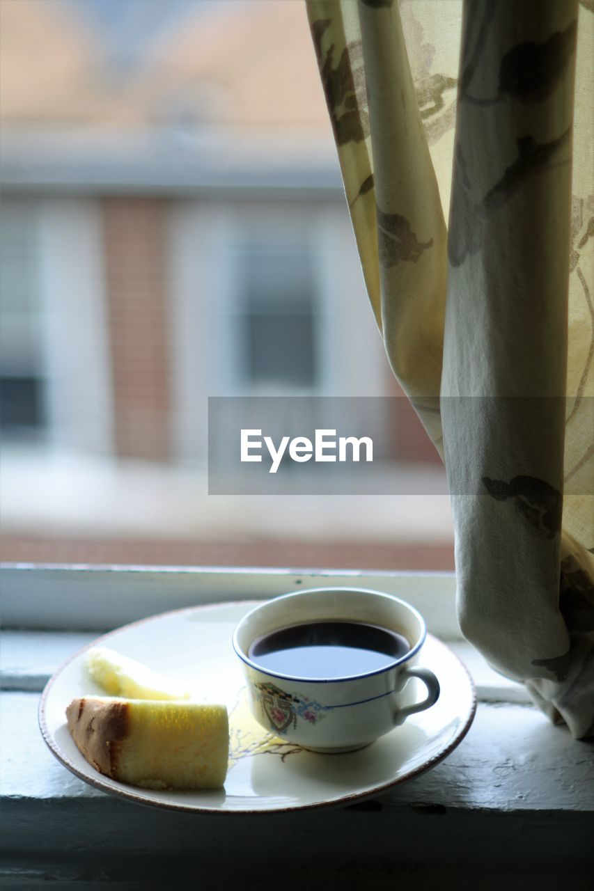 CLOSE-UP OF COFFEE SERVED ON TABLE AGAINST WINDOW