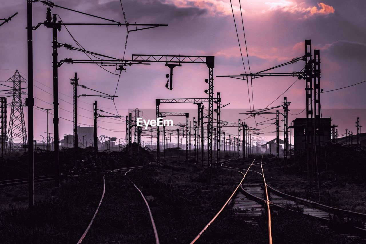 Railroad tracks against sky during sunset