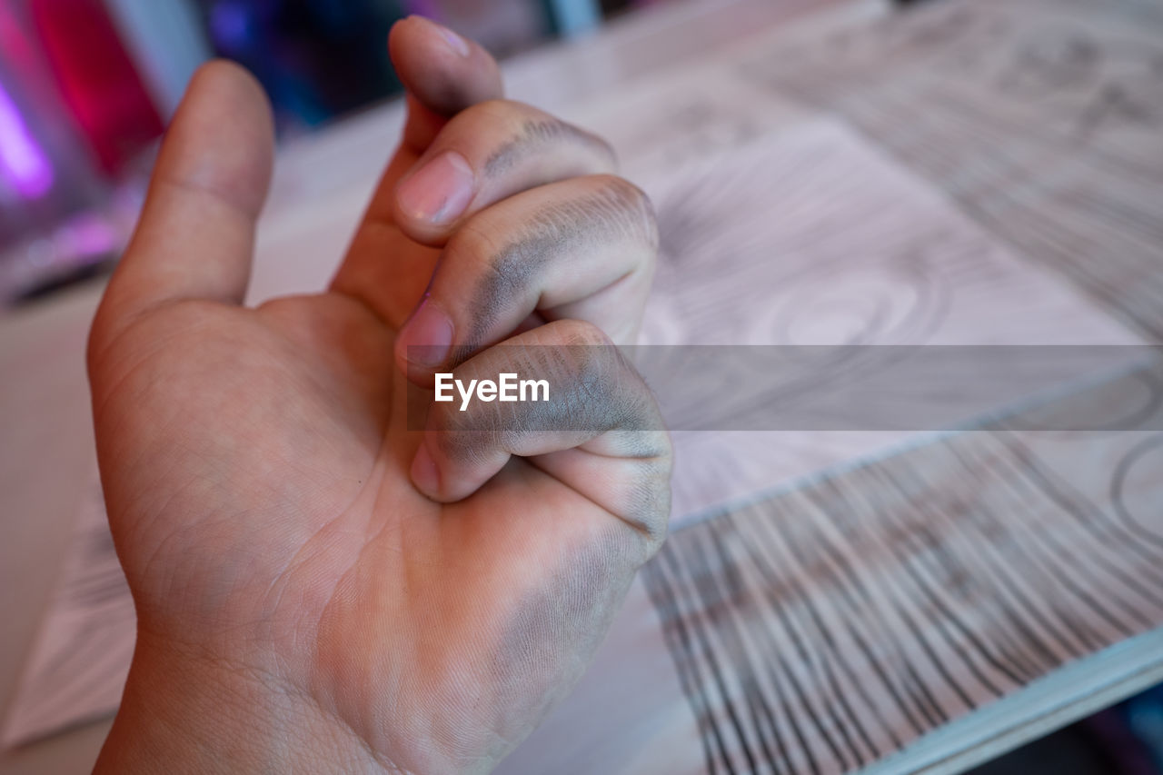 HIGH ANGLE VIEW OF PERSON HAND ON BED