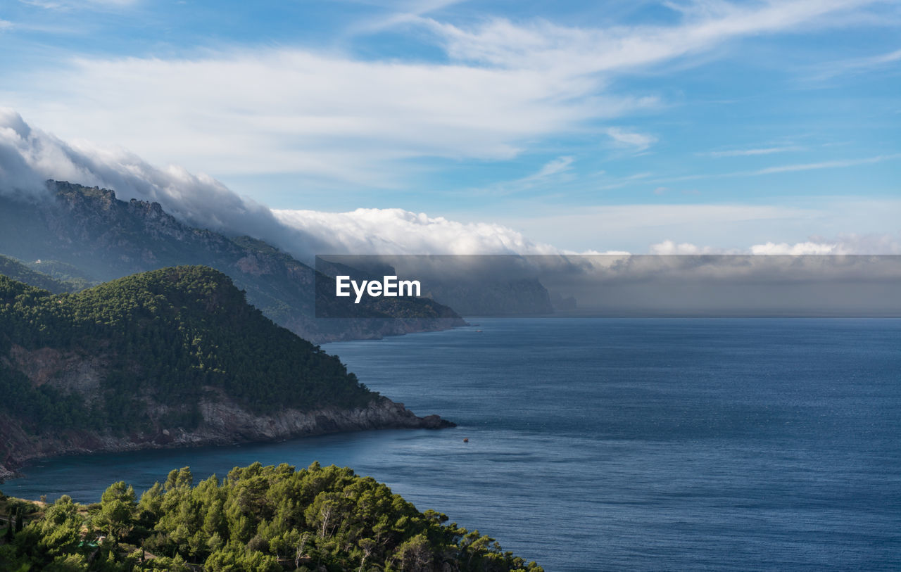 Scenic view of sea and mountains against sky