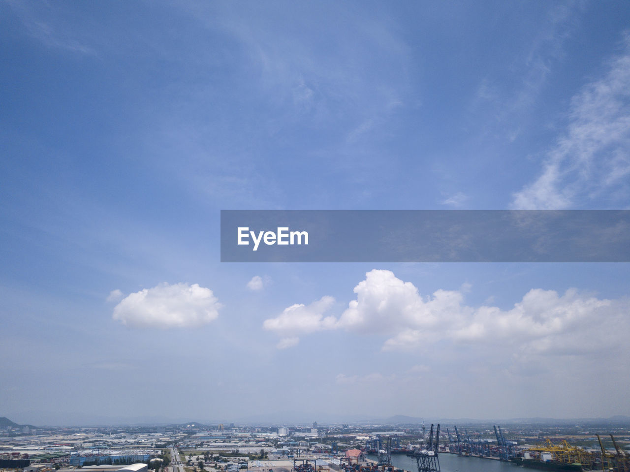 AERIAL VIEW OF BUILDINGS AGAINST CLOUDY SKY