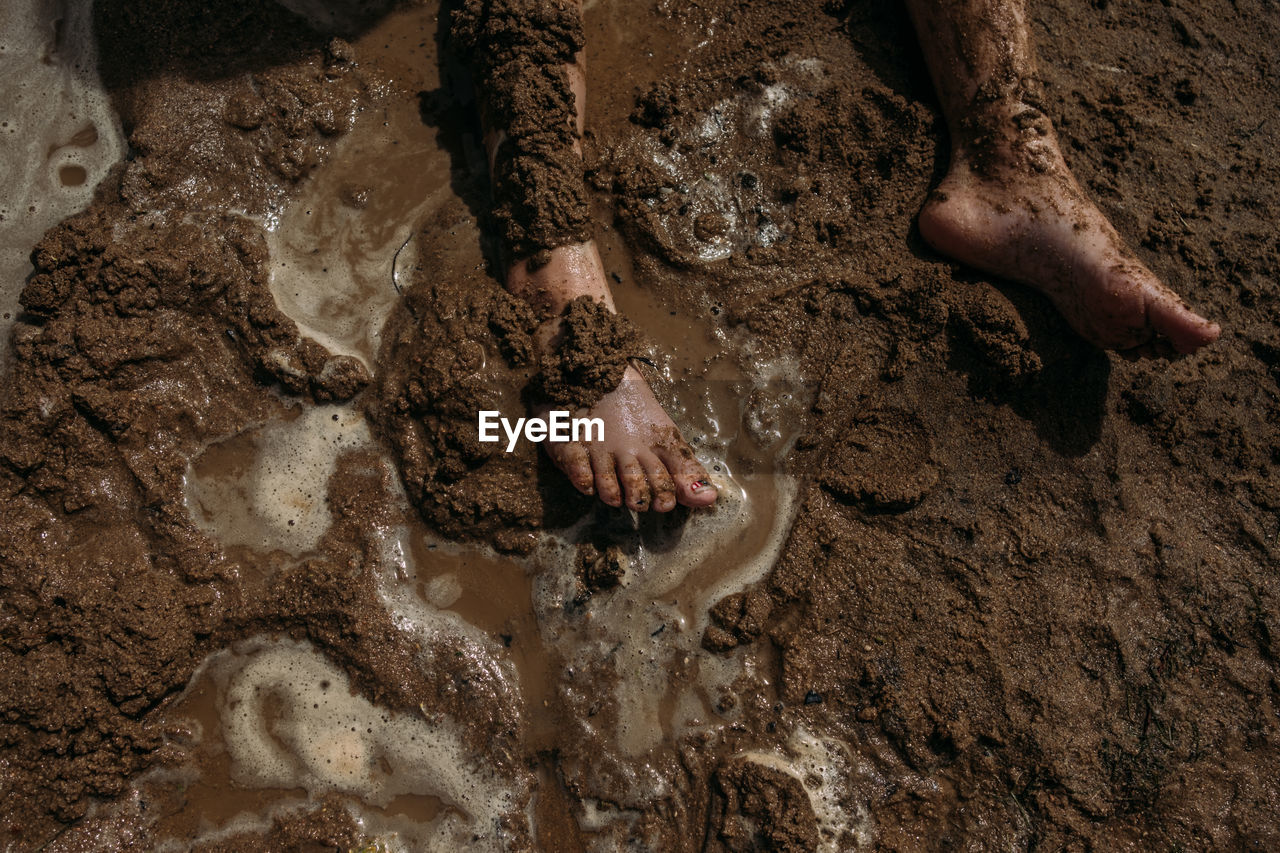 Young child's legs covered in mud