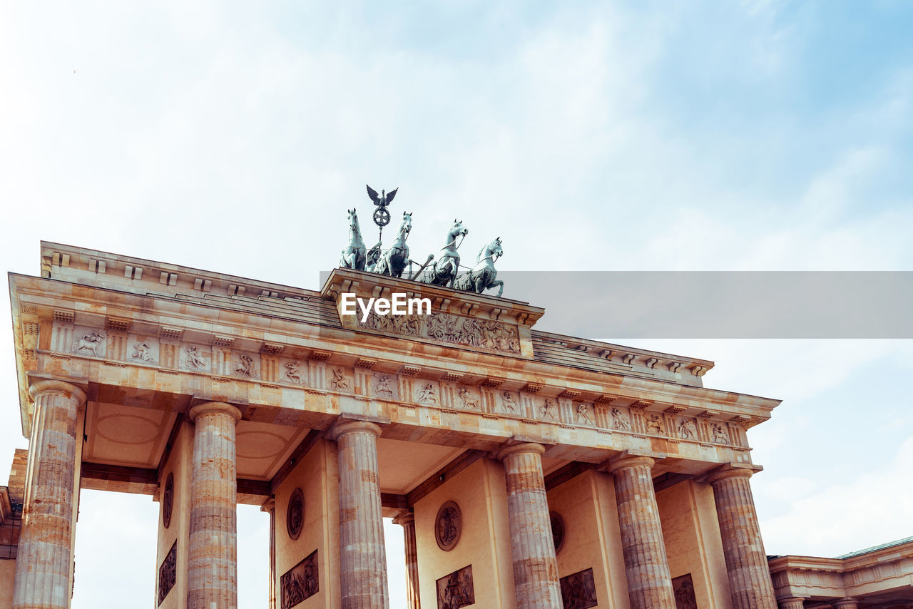 Low angle view of quadriga on brandenburg gate against sky