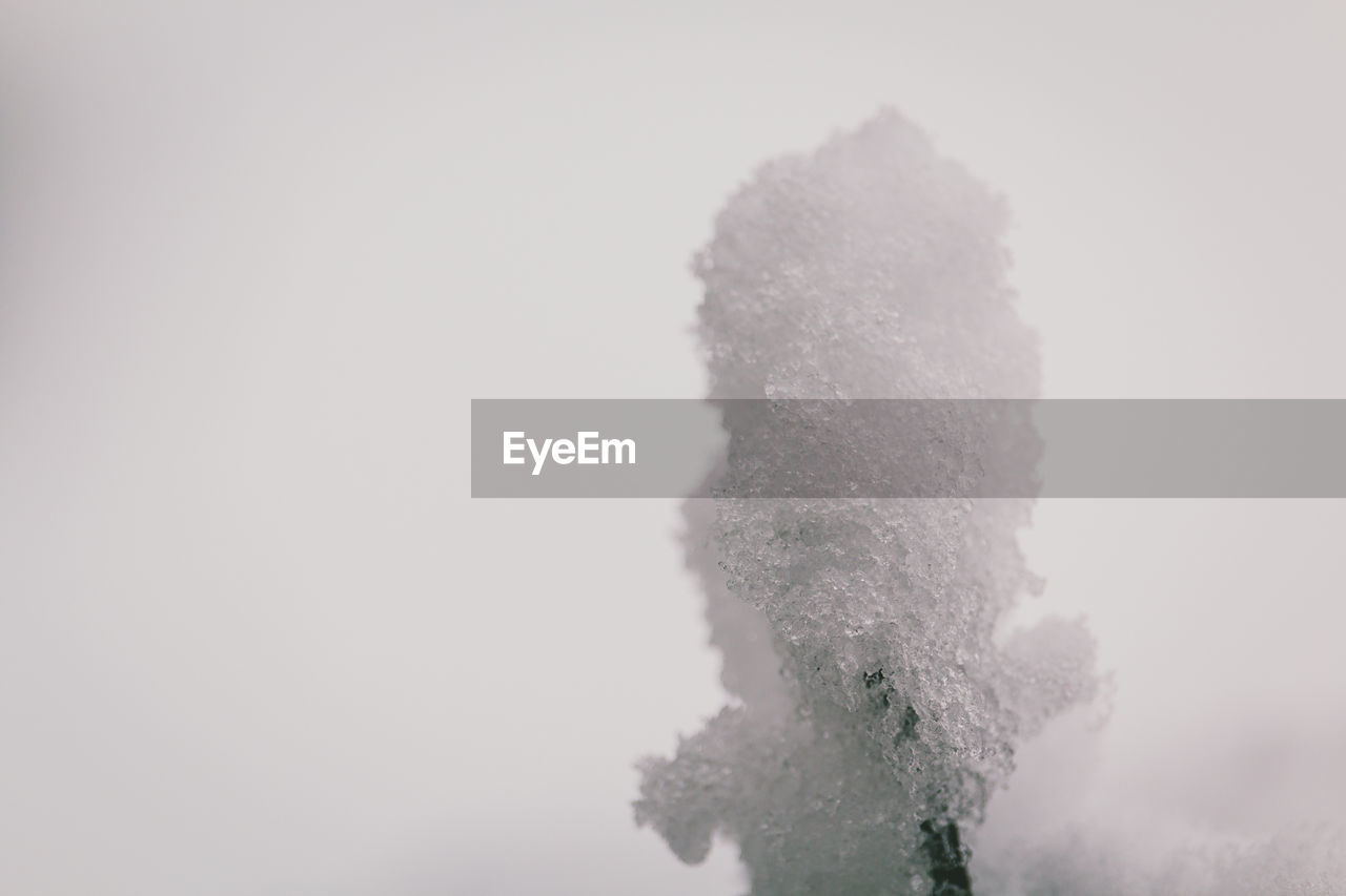 CLOSE-UP OF FROZEN SNOW AGAINST SKY