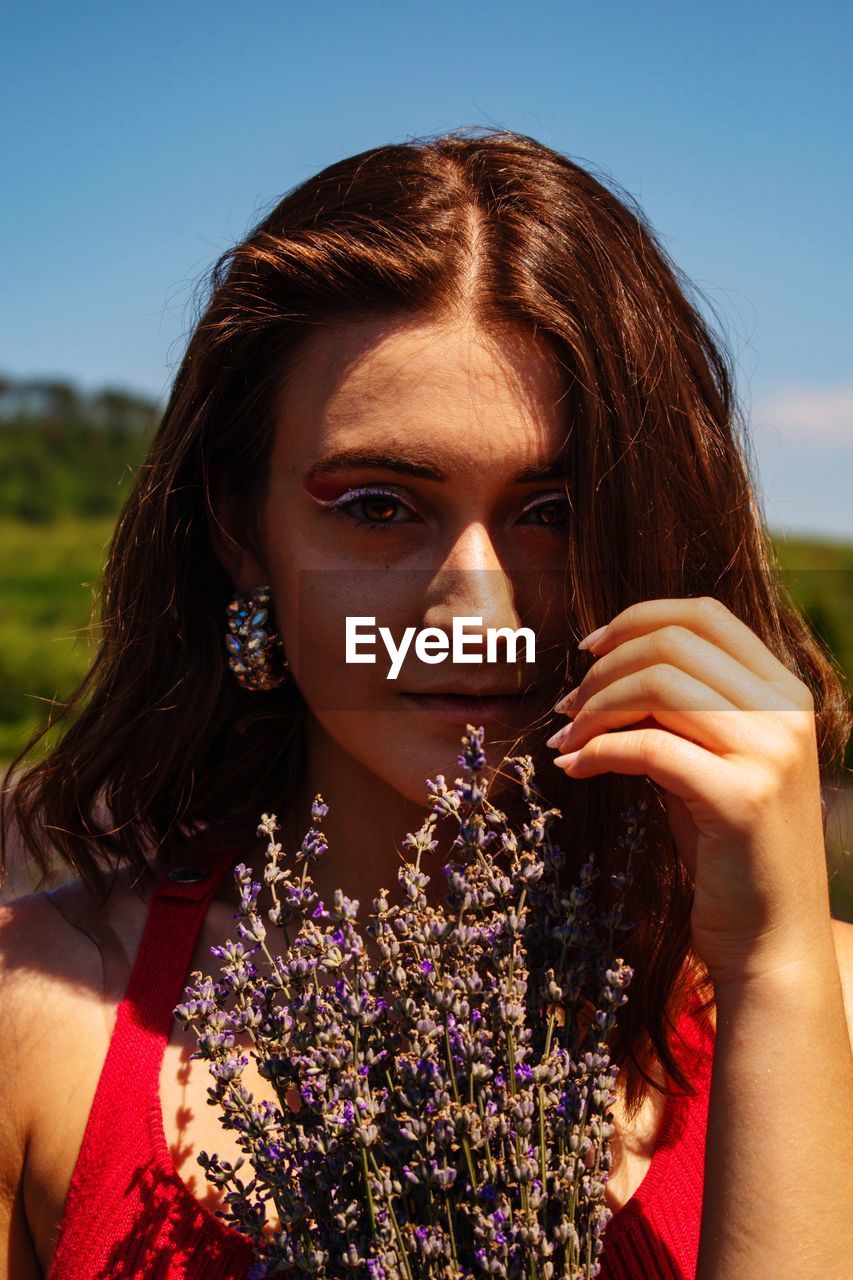 Portrait of beautiful young woman with wild eyes and a lavender bouquet