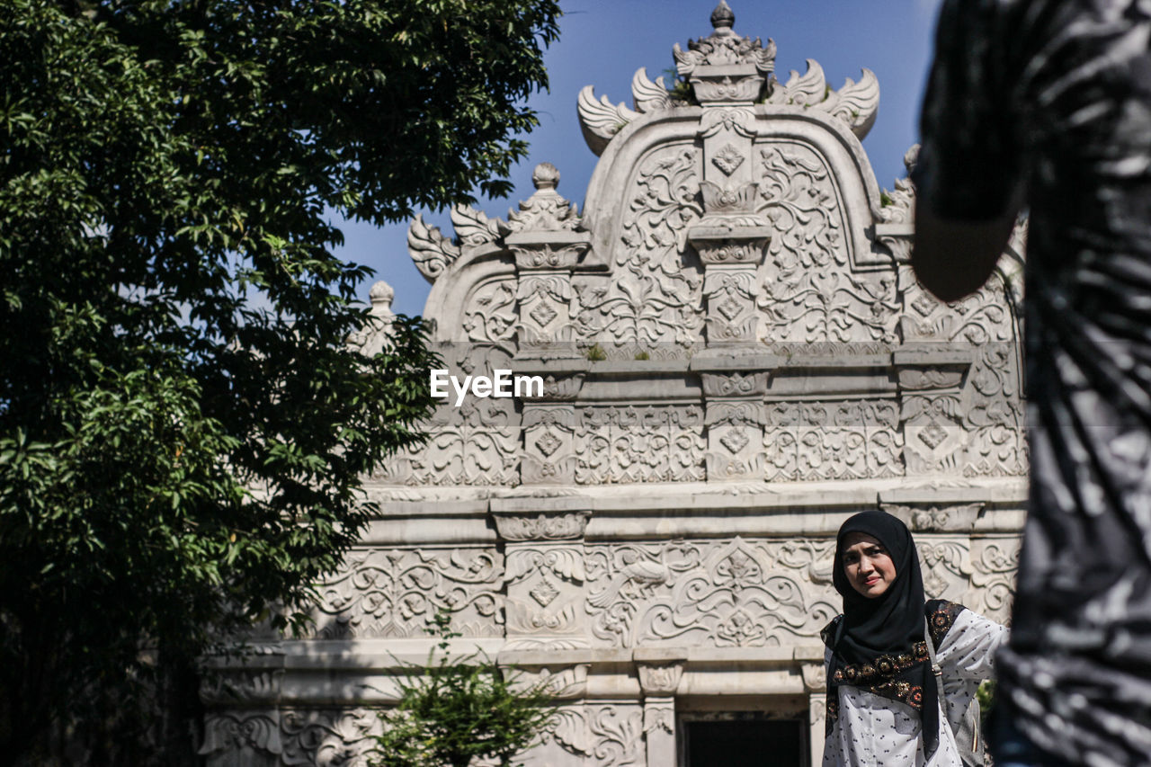 Young woman standing against historic temple