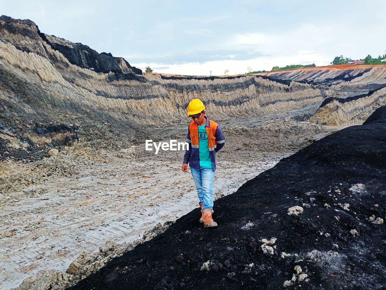 REAR VIEW OF PERSON STANDING ON ROCK