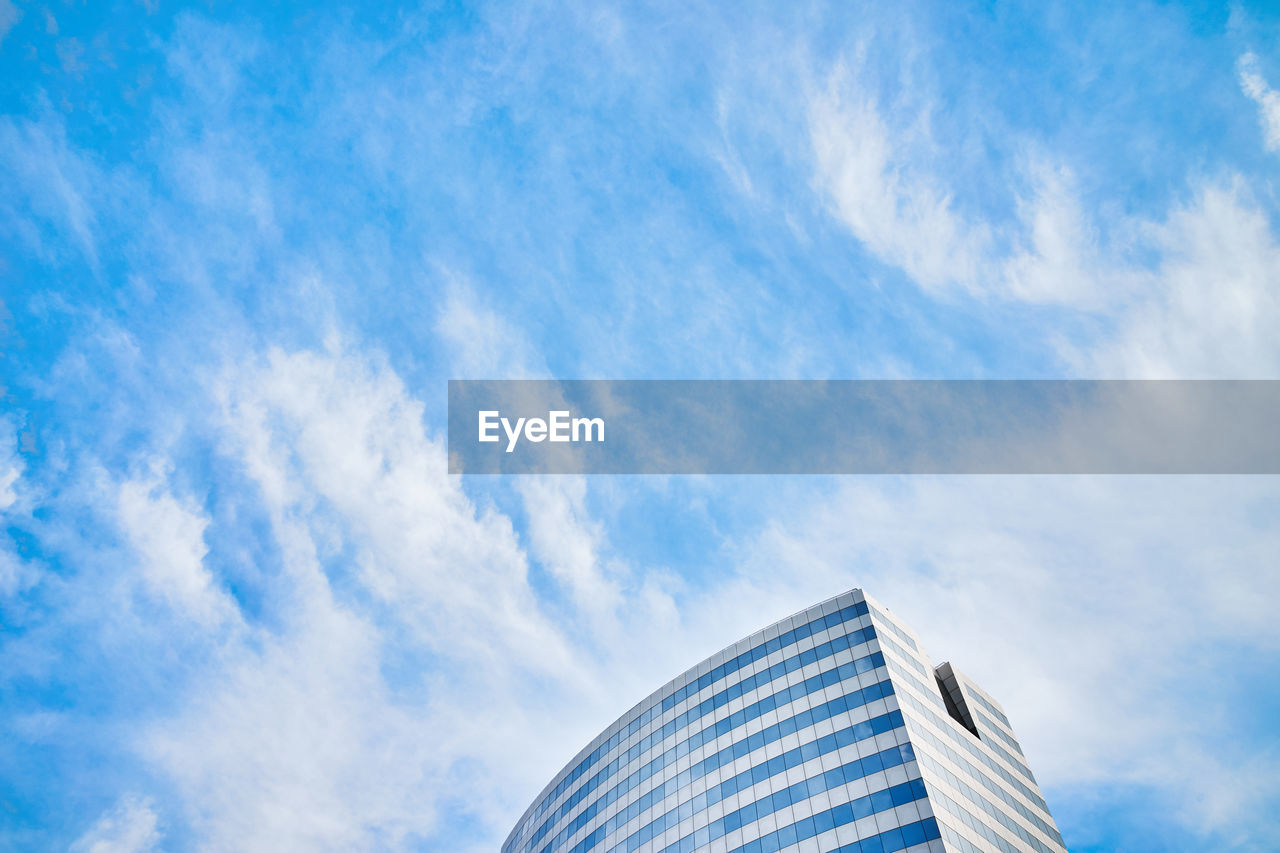 Low angle view of modern building against blue sky