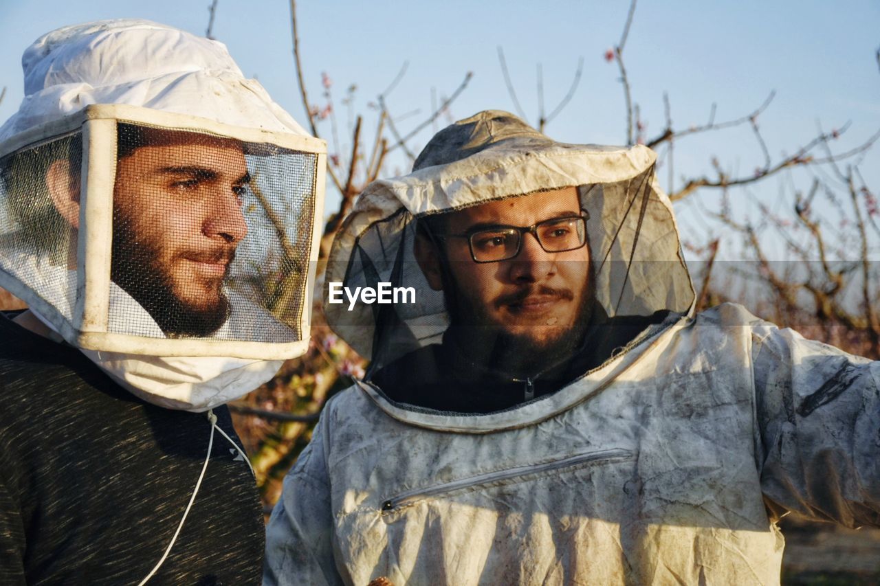 Portrait of two friends wearing special costumes to protect them from bees