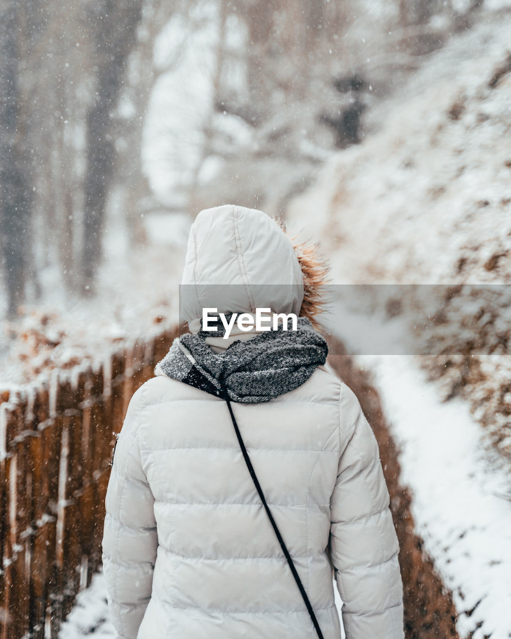 Rear view of woman walking on snow covered land