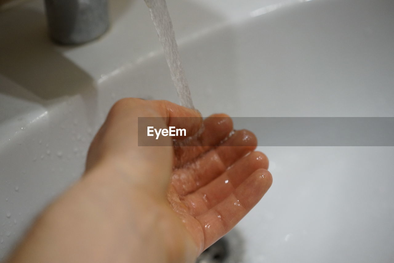 CLOSE-UP OF HAND TOUCHING WATER