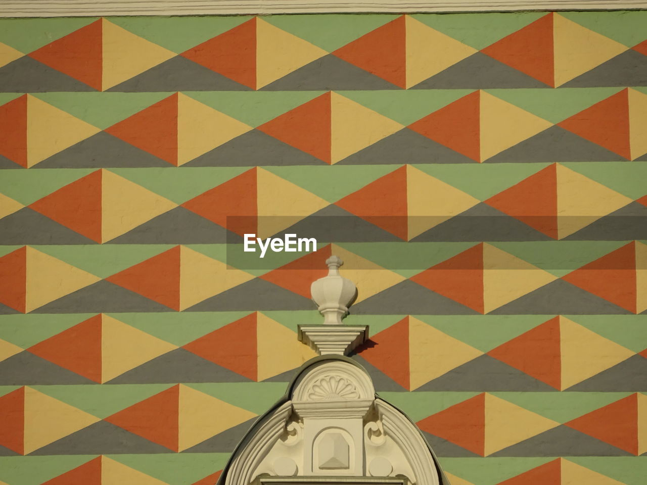 LOW ANGLE VIEW OF MAN PAINTING AGAINST WALL