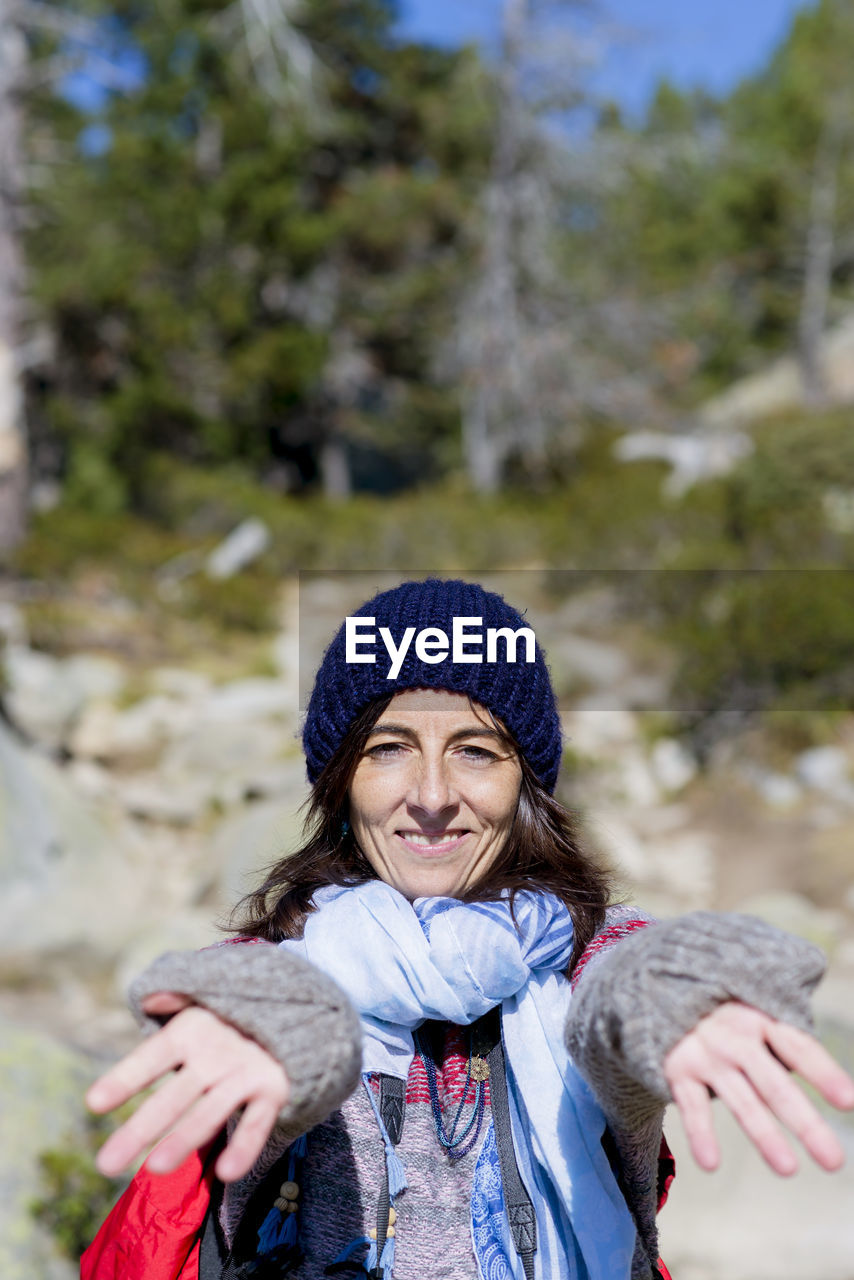 Portrait of smiling woman in forest during winter