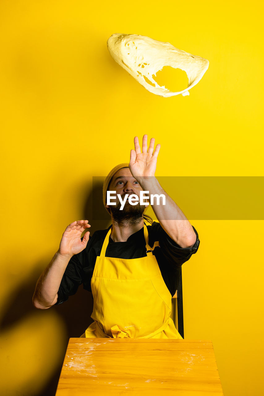 Chef preparing food against colored background