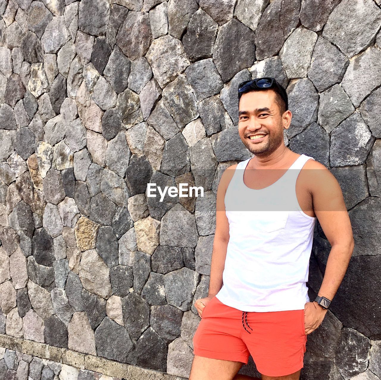 Portrait of smiling man standing against wall