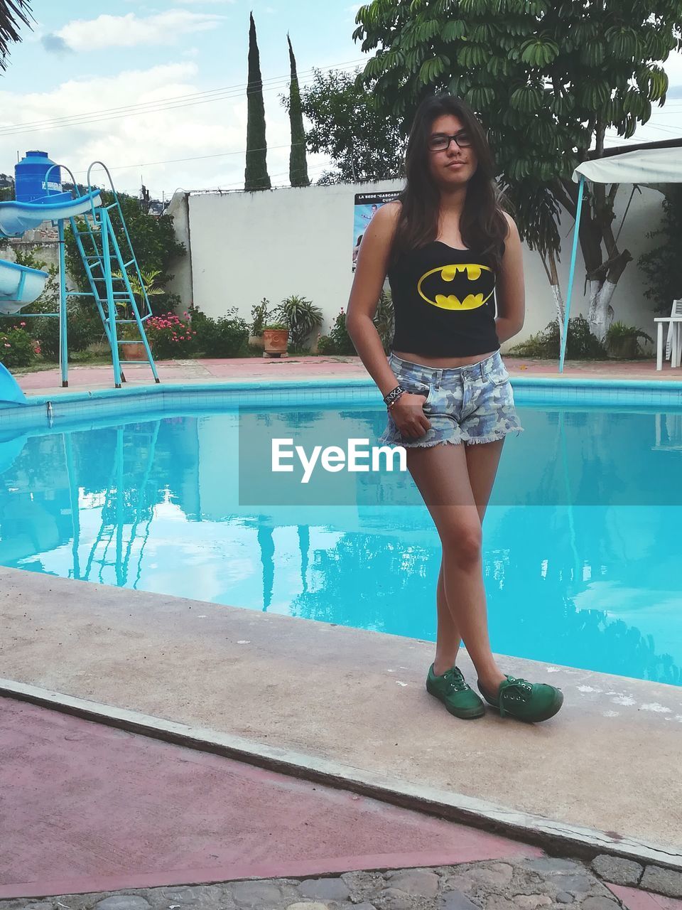 PORTRAIT OF HAPPY WOMAN STANDING IN SWIMMING POOL