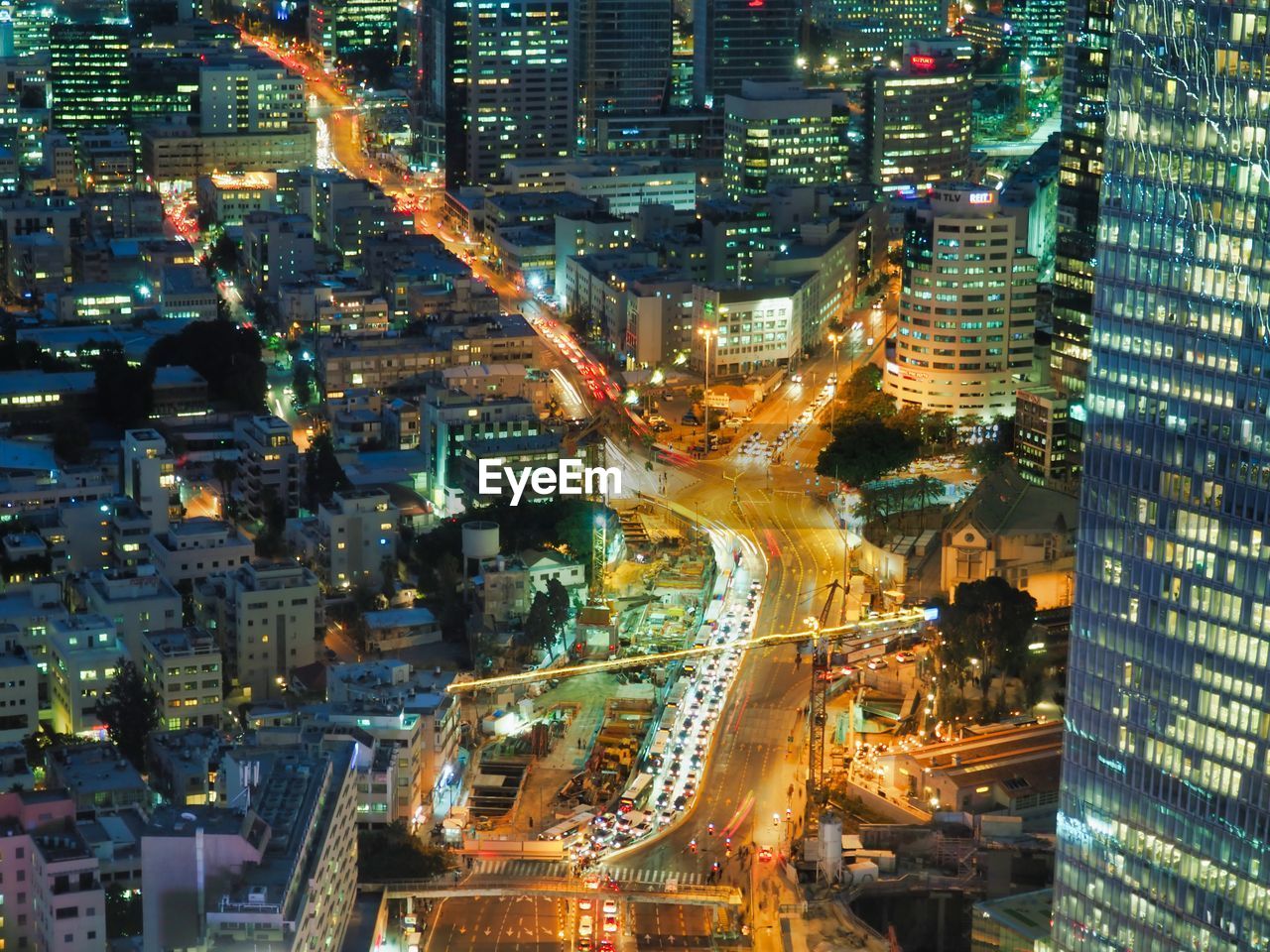 HIGH ANGLE VIEW OF ILLUMINATED CITY BUILDINGS AT NIGHT