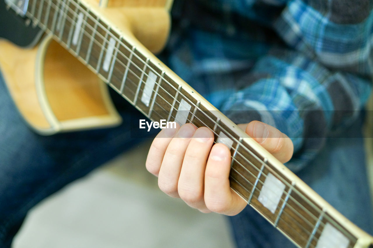 Close-up of man playing guitar