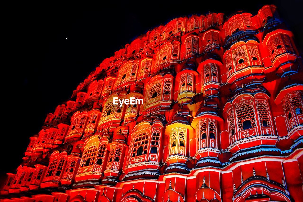 Low angle view of illuminated building against sky at night