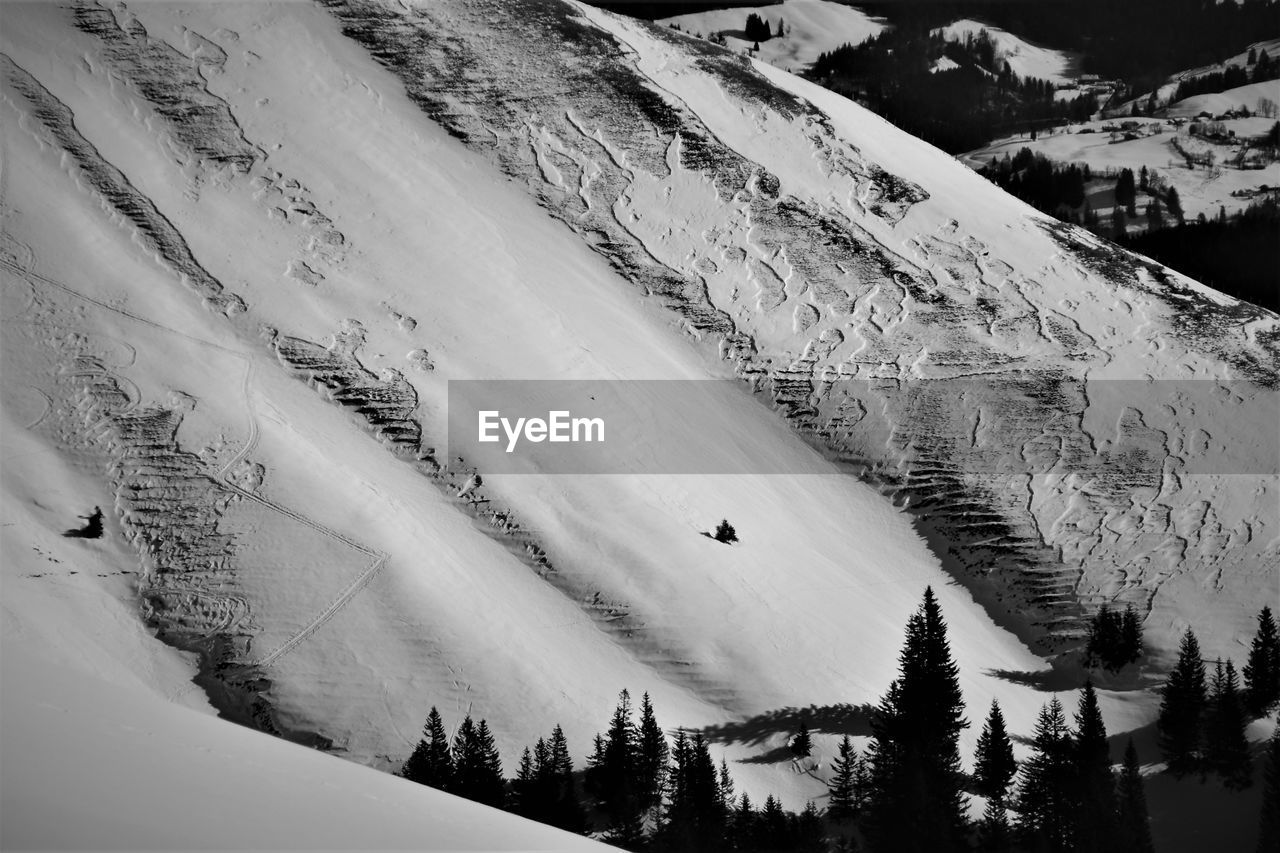 HIGH ANGLE VIEW OF SNOW COVERED LANDSCAPE AGAINST MOUNTAIN