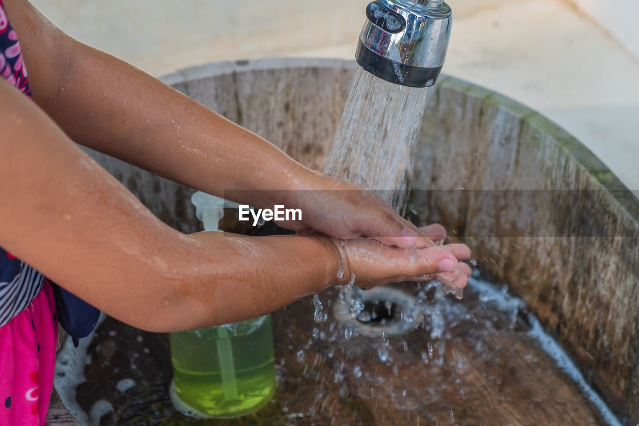 MIDSECTION OF PERSON IN DRINKING WATER FROM GLASS