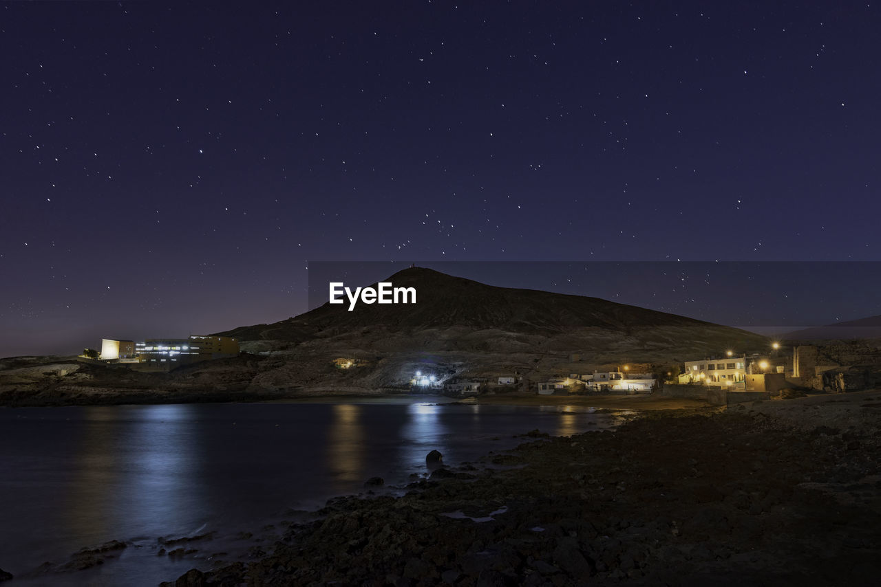 Scenic view of illuminated mountains against sky at night