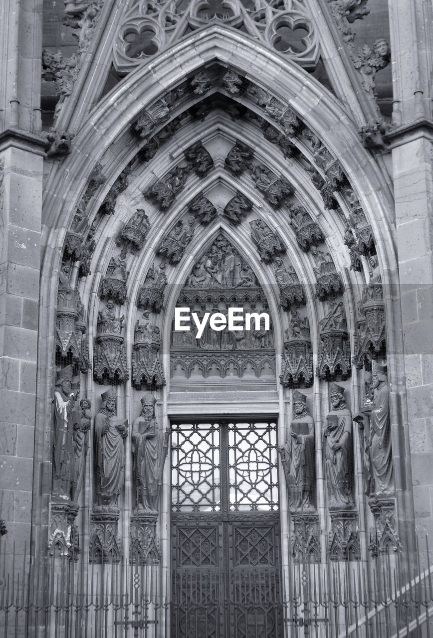 Monochrome photography of arched cathedral entrance in gothic style