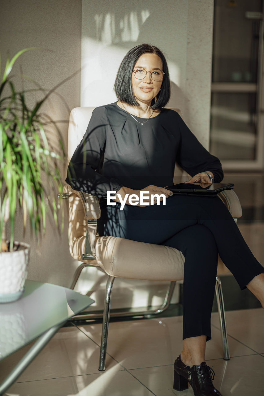 Work-life-balance, businesswoman in a chair in the lobby with a tablet