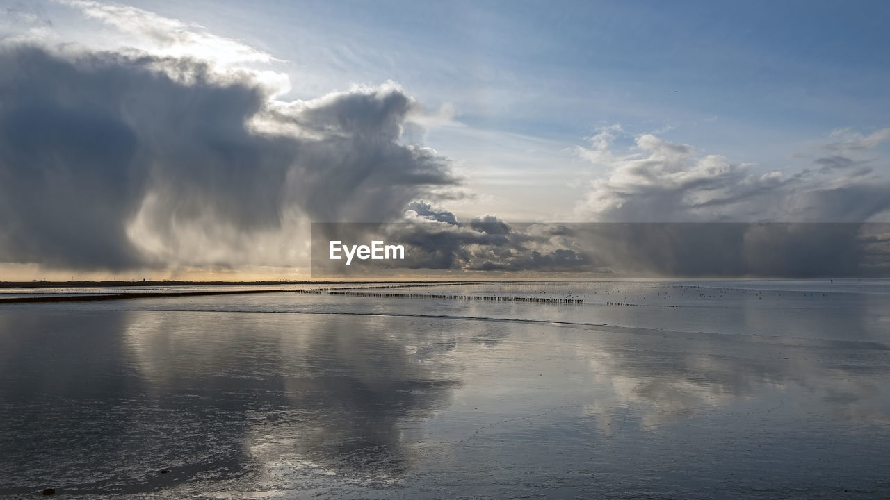 Incredible cloudscape at the wadden sea near holwerd in the netherlands at sunset