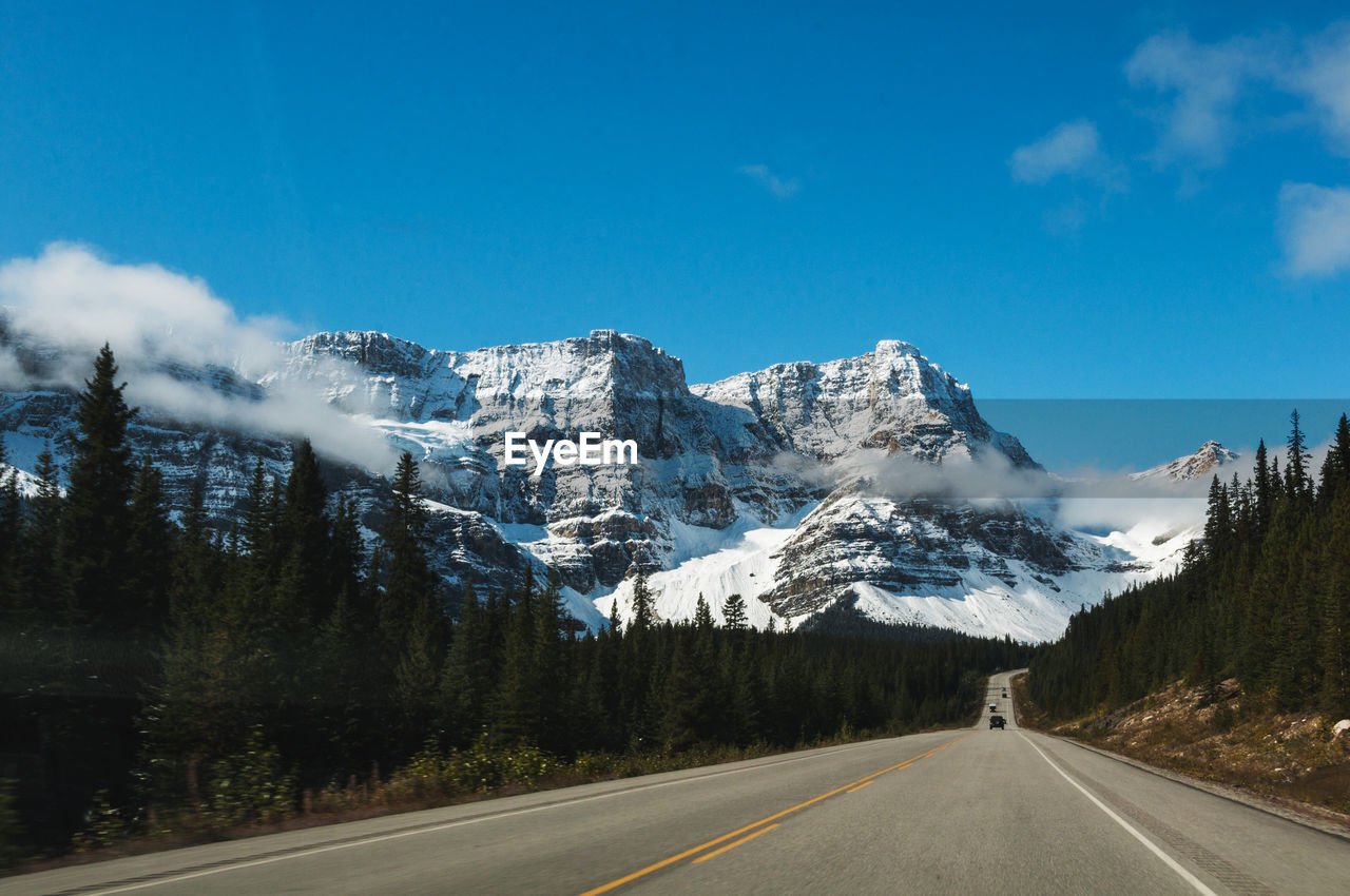 ROAD BY SNOWCAPPED MOUNTAIN AGAINST SKY