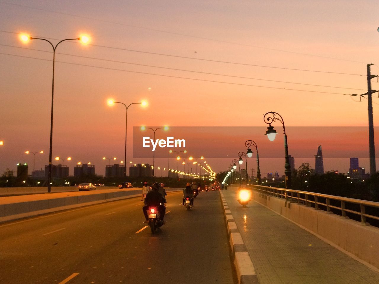 Illuminated vehicles on street against sky