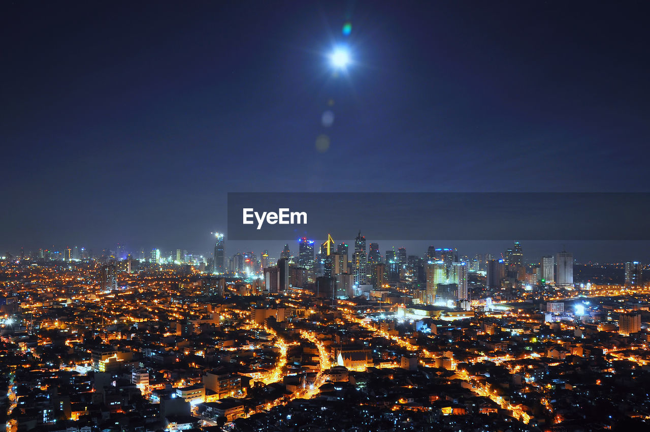 Illuminated cityscape against sky at night