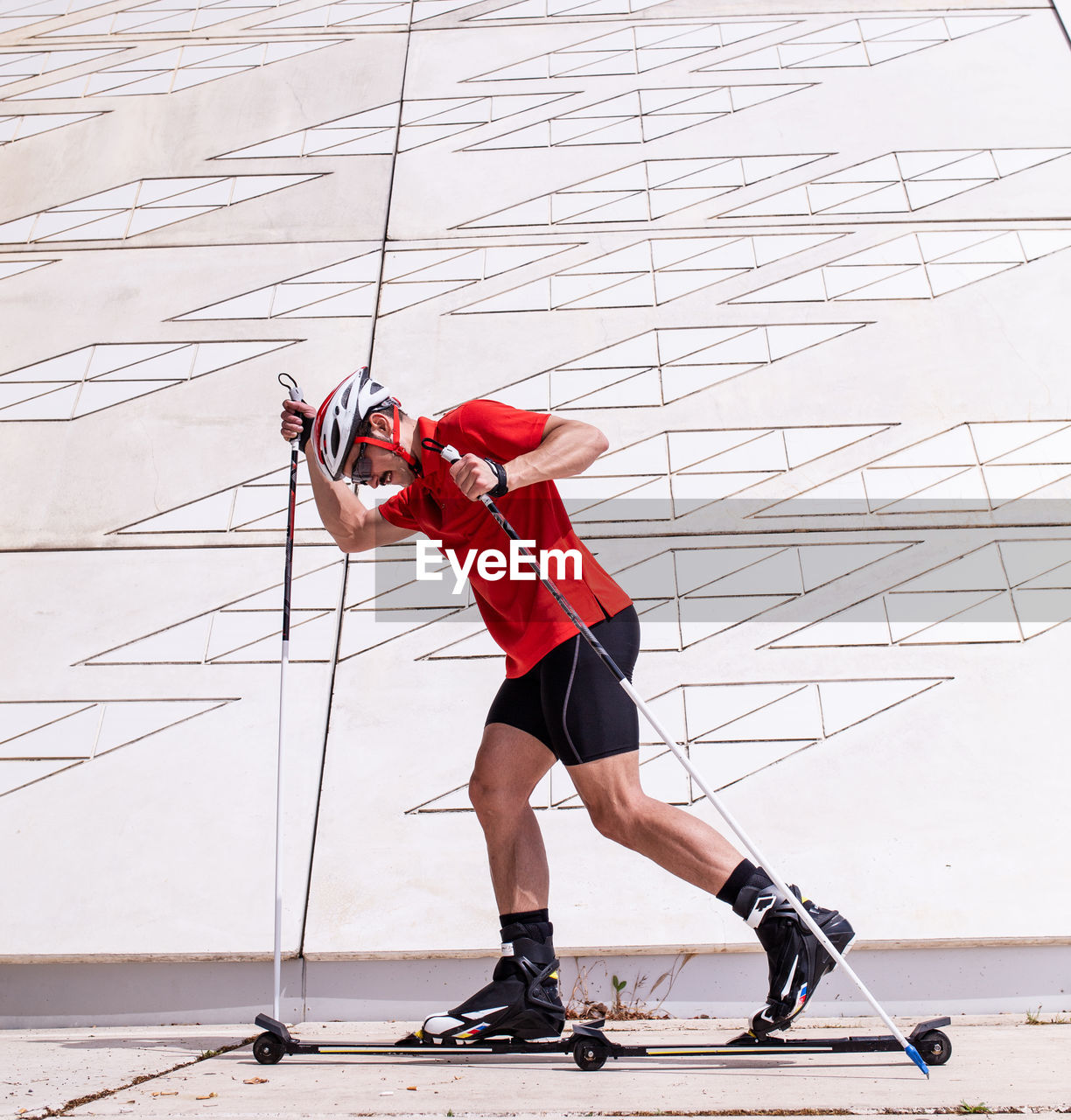Side view of man with ski roller against wall