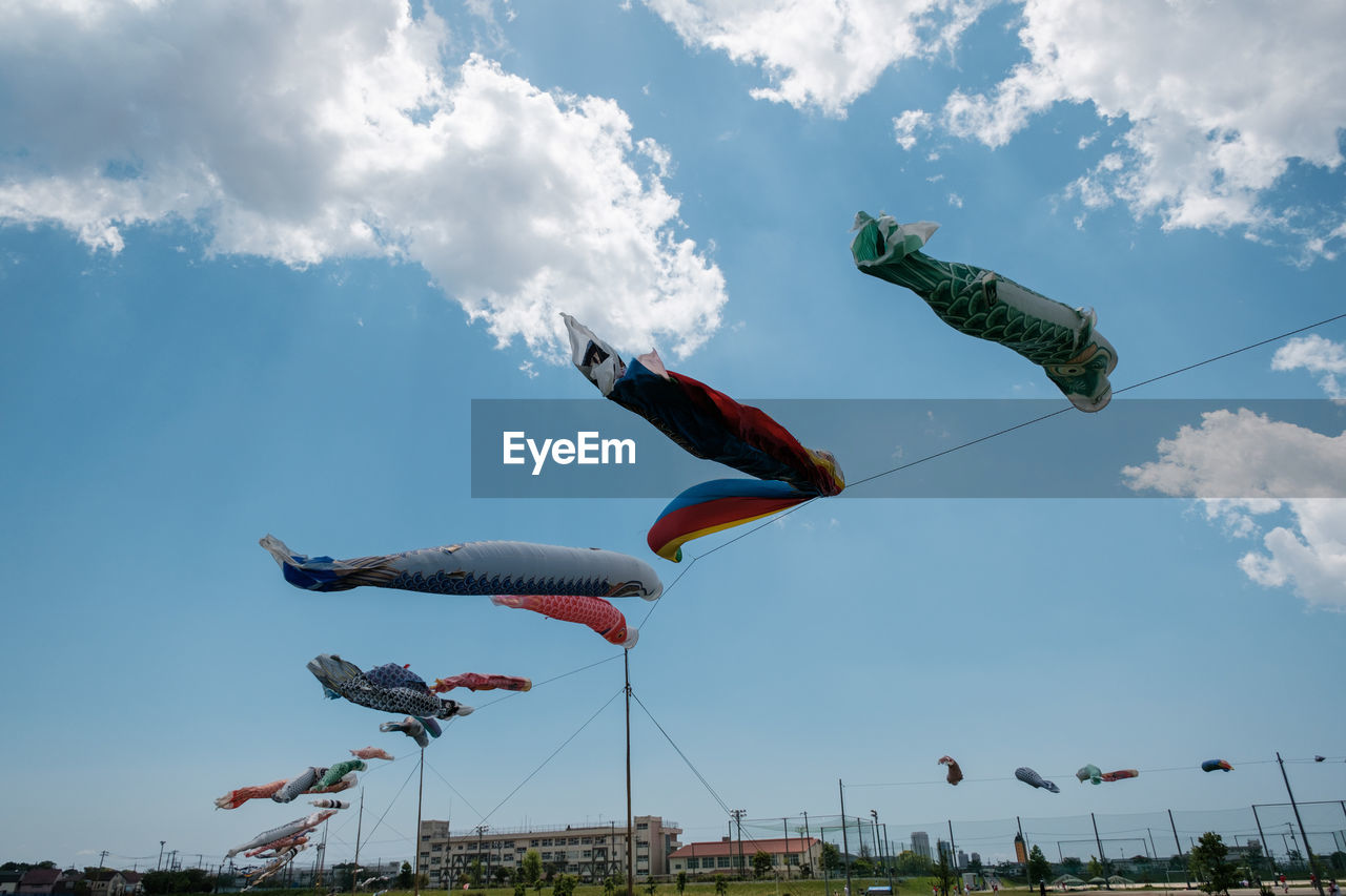 Low angle view of fish streamers  flying against sky