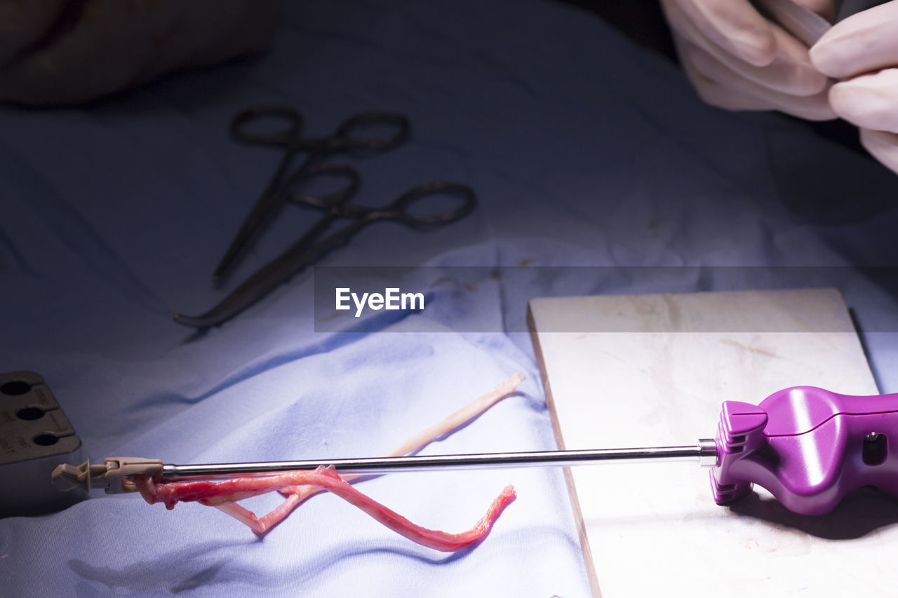 Cropped hand of doctor by medical equipment on table