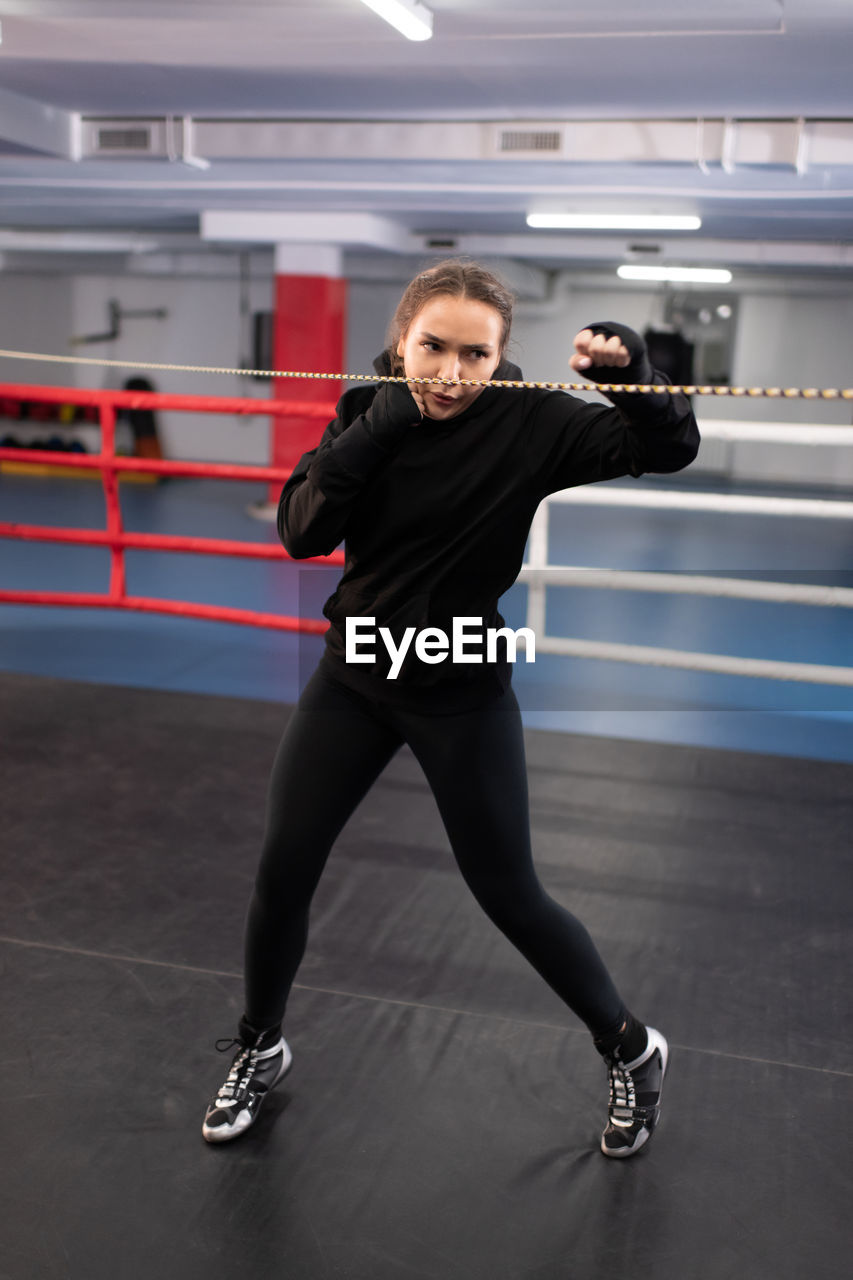 Strong fighter practicing hooks on boxing ring